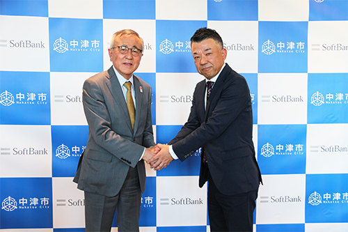 中津市長の奥塚 正典氏(左)とソフトバンクの営業第二本部 本部長の田口 貴将